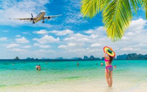 海と女性の上を飛ぶ飛行機